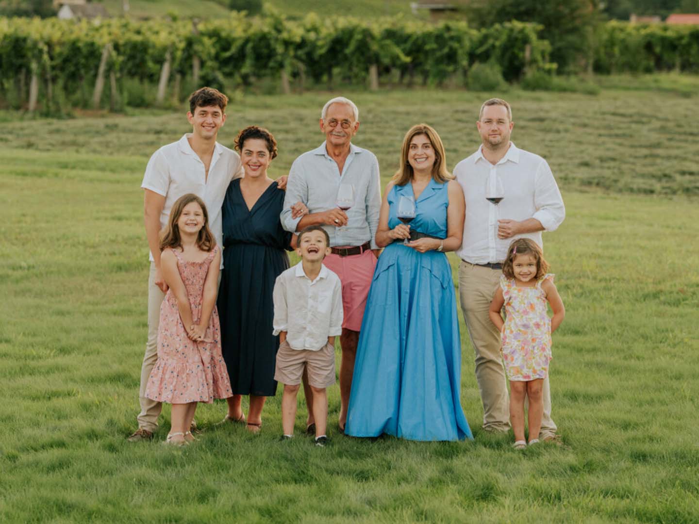 Familie Sauska mit Weingläsern in einem Weinberg des Weinguts Sauska.